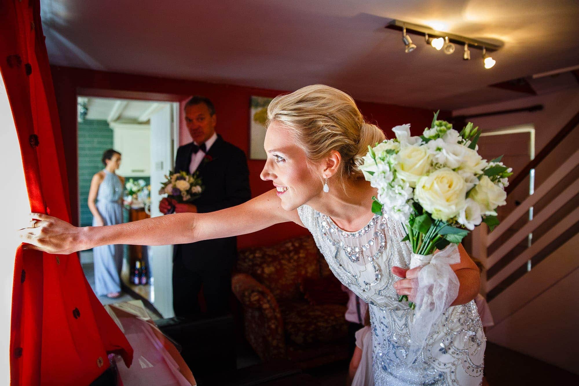 Bride looking out of window just before wedding ceremony by Carol Tansley Hampshire Wedding Photographer